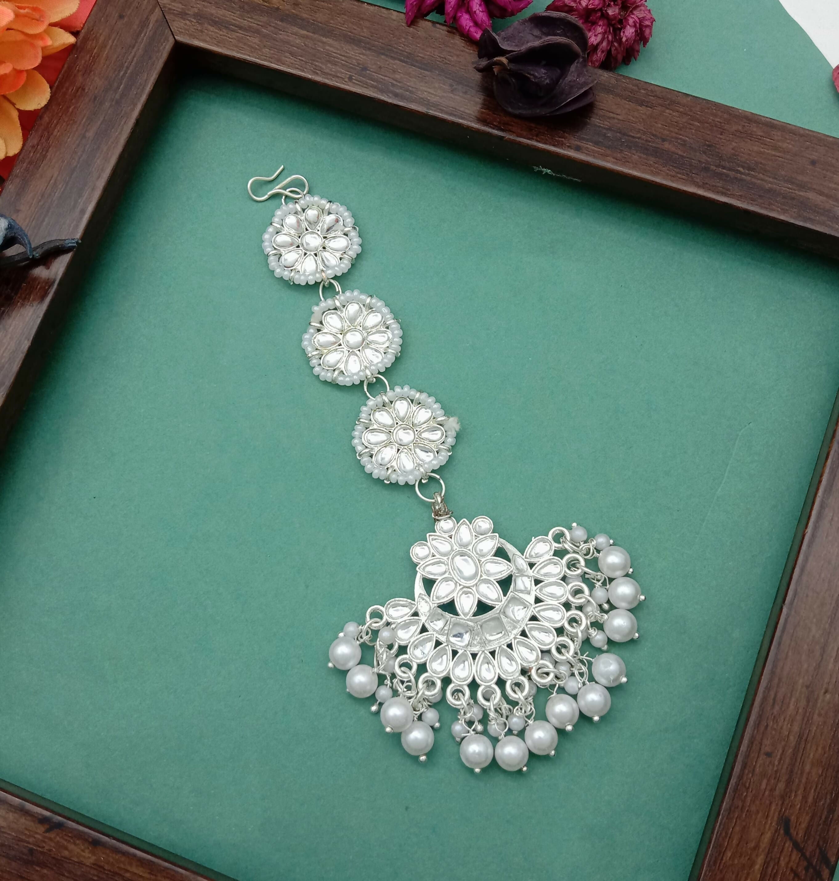 Enhance your ethnic look with this elegant White Gold Plated Kundan Maang Tika, designed to add timeless charm and grace to your traditional attire. Crafted with precision, this beautiful piece features sparkling artificial stones and delicate bead detail