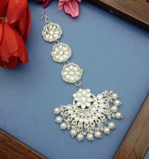 Enhance your ethnic look with this elegant White Gold Plated Kundan Maang Tika, designed to add timeless charm and grace to your traditional attire. Crafted with precision, this beautiful piece features sparkling artificial stones and delicate bead detail